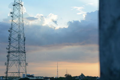 Low angle view of electricity pylon against sky during sunset