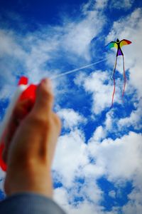Low angle view of people against cloudy sky