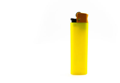 Close-up of yellow cigarette lighter against white background