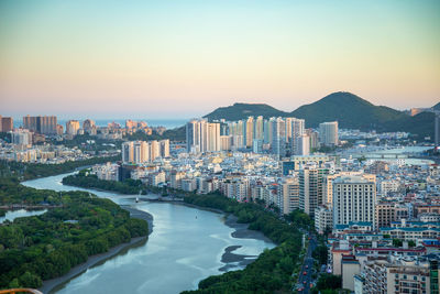 High angle view of city buildings against sky at sunset