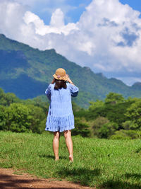 Asian woman vacation in natural green glass field with mountain view