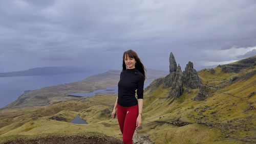 Woman standing on mountain against sky