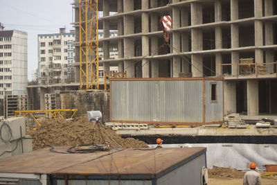 Construction site by buildings in city