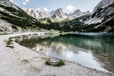 Scenic view of lake by mountains against sky