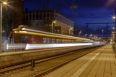 Illuminated railroad station against sky at night