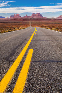 Empty road leading towards monument valley