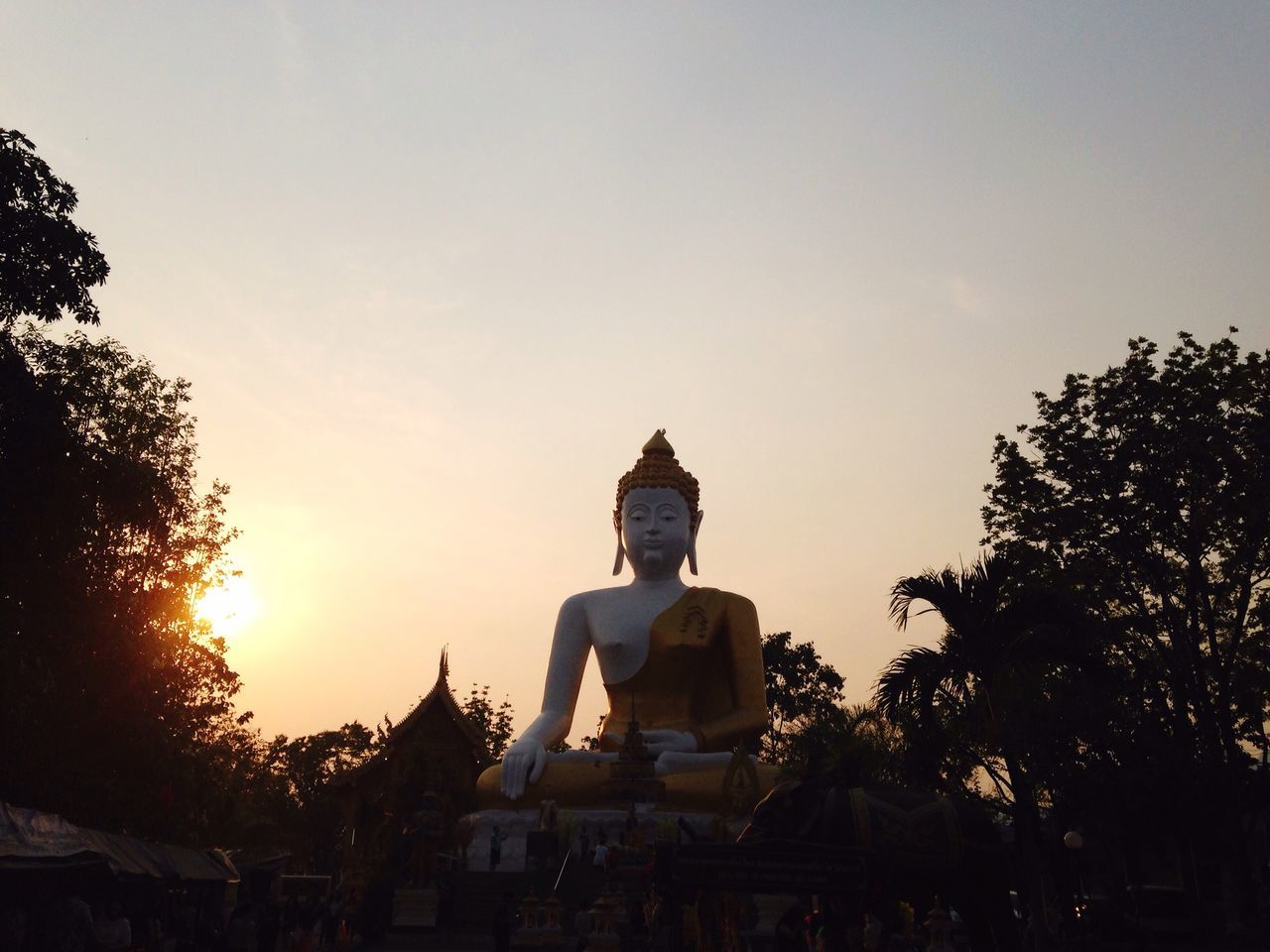 clear sky, statue, religion, sculpture, copy space, human representation, spirituality, art and craft, sunset, tree, art, temple - building, place of worship, creativity, built structure, architecture, famous place, building exterior