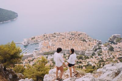 Rear view of couple enjoying the view of a croatian village on the sea