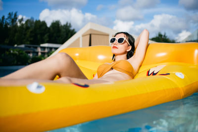 Young woman lying down in swimming pool