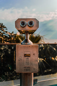 Close-up of coin-operated binoculars against sky