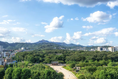 Panoramic view of trees and buildings in city against sky