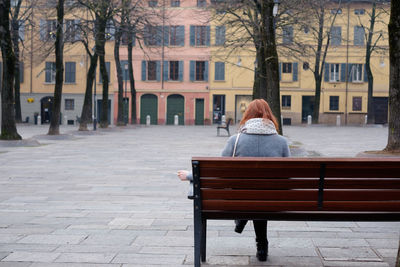 Rear view of woman walking on sidewalk