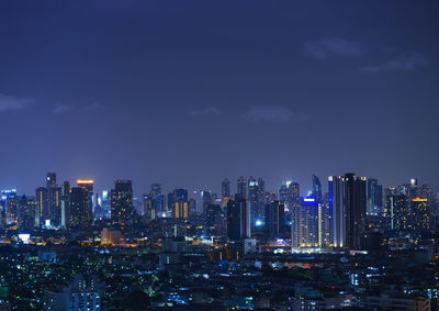 Illuminated cityscape against sky at night