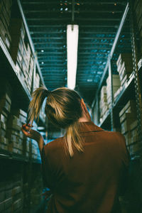 Rear view of woman standing against illuminated building