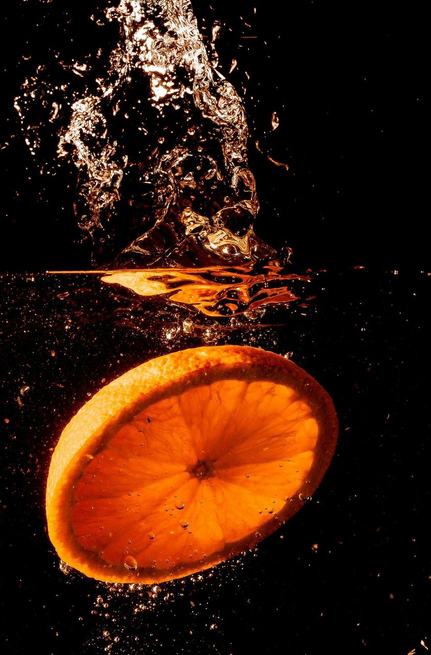 food and drink, orange, orange color, food, citrus fruit, fruit, astronomical object, no people, nature, healthy eating, yellow, motion, freshness, night, water, still life photography, wellbeing, close-up, studio shot, tangerine, black background, indoors, darkness, splashing
