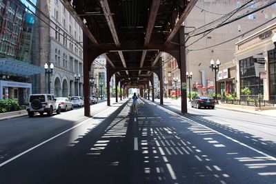 Photographer standing in the middle of the street with l train overhead