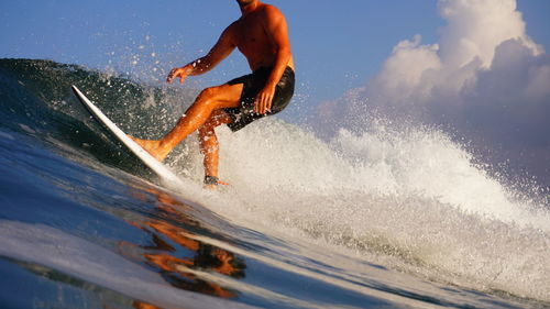 Man surfing in sea against sky