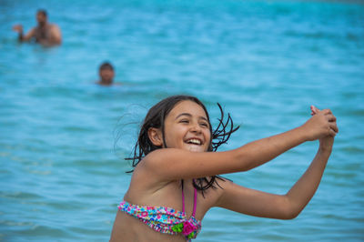 Happy girl standing in swimming pool