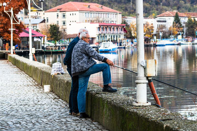 Man standing on canal in city