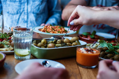 Cropped image of friends having lunch on table