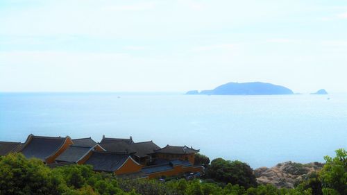 Scenic view of sea and buildings against sky