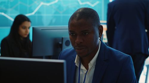 Portrait of businessman using laptop at office
