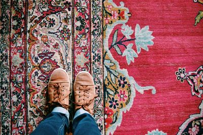 Low-section of man standing on old fashioned rug