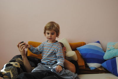 Cute boy with father on sofa at home