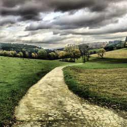 Scenic view of field against cloudy sky