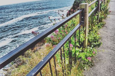 High angle view of railing by sea against sky