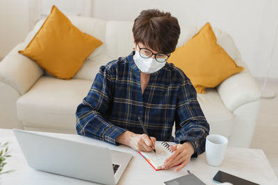 Woman wearing mask working from home