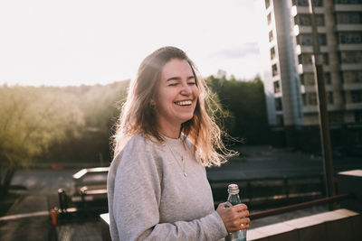 Young woman smiling while standing in city