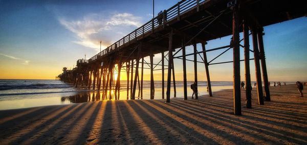 Pier over sea against sky during sunset