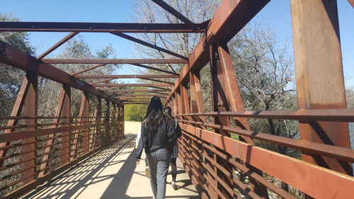 Rear view of woman standing on footbridge