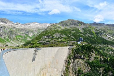 Scenic view of dam and mountains against sky