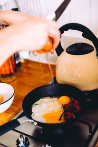 Cropped image hands preparing omelet in kitchen