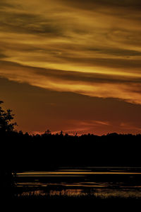 Scenic view of lake against orange sky