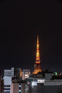 Illuminated buildings against clear sky at night