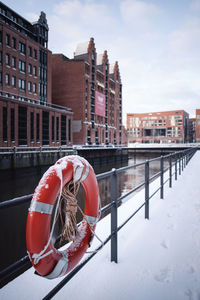 Canal in city against sky during winter