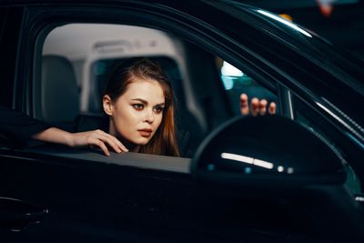 Portrait of young woman sitting in car