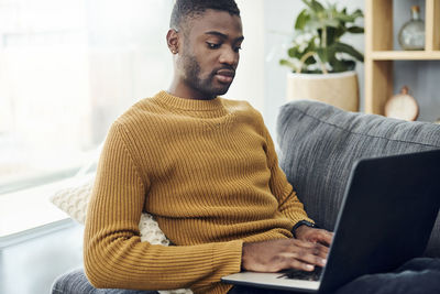 Young man using mobile phone at home