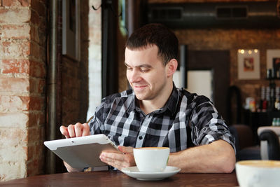 Young man drinking coffee in restaurant