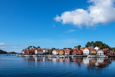 Buildings by houses against blue sky