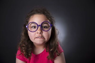 Close-up portrait of girl against black background