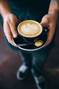 Close-up of hand holding coffee cup