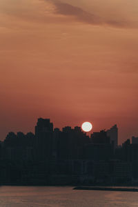 Silhouette buildings against romantic sky at sunset