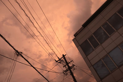 Low angle view of power lines against sky at sunset