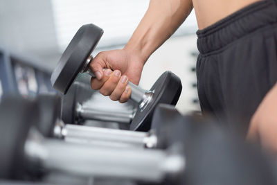 Close-up of hands lifting dumbbell