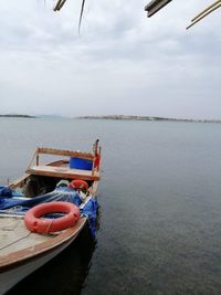 Boat moored in sea against sky