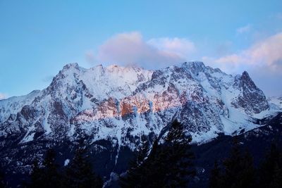 Low angle view of snow against sky during sunset